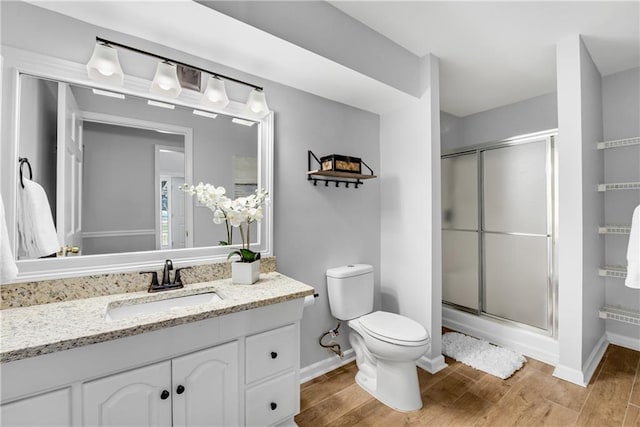 full bathroom with toilet, wood finished floors, and a shower stall