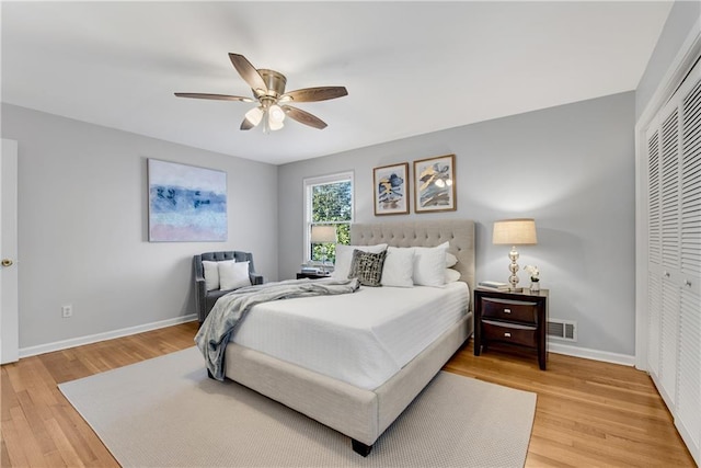 bedroom featuring a closet, baseboards, visible vents, and light wood finished floors