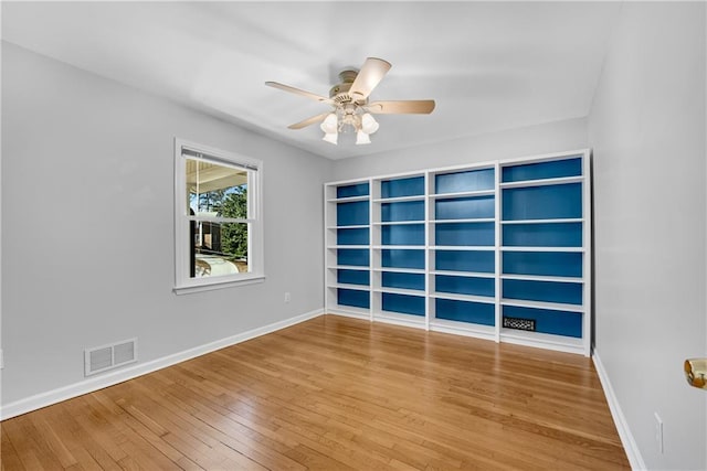 unfurnished room with visible vents, baseboards, ceiling fan, and hardwood / wood-style flooring