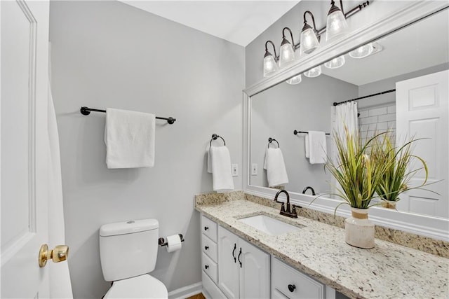 bathroom with vanity, curtained shower, and toilet