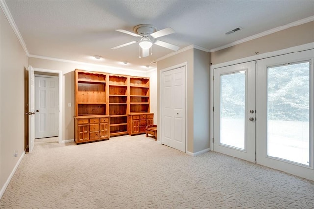 interior space with access to exterior, french doors, crown molding, visible vents, and light carpet