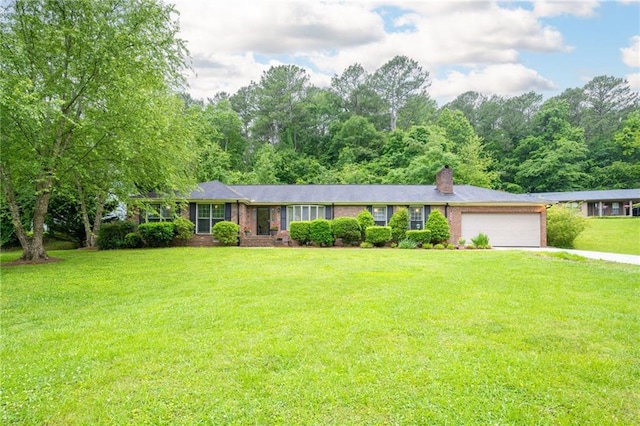 single story home featuring an attached garage, driveway, a chimney, and a front yard