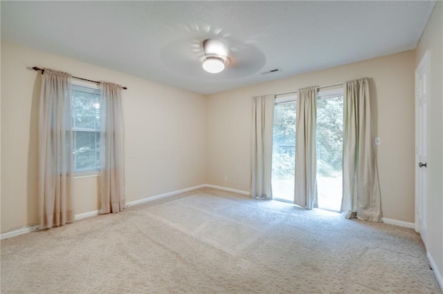 unfurnished room with light colored carpet, visible vents, and baseboards