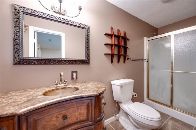 full bathroom featuring toilet, an enclosed shower, a textured ceiling, vanity, and tile patterned flooring