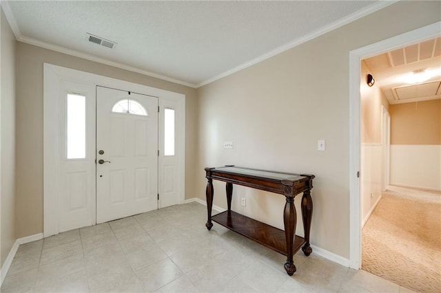 foyer entrance featuring visible vents and crown molding