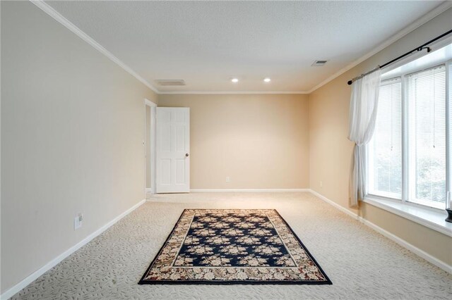 unfurnished room with visible vents, baseboards, crown molding, and carpet flooring