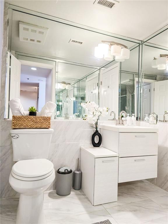 3481 Lakeside Dr NE Unit 2204, Atlanta, GA 30326 - bathroom featuring vanity, marble finish flooring, and tile walls