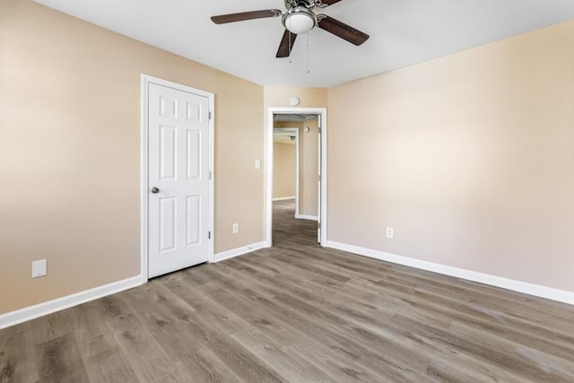 unfurnished bedroom featuring a ceiling fan, baseboards, and wood finished floors