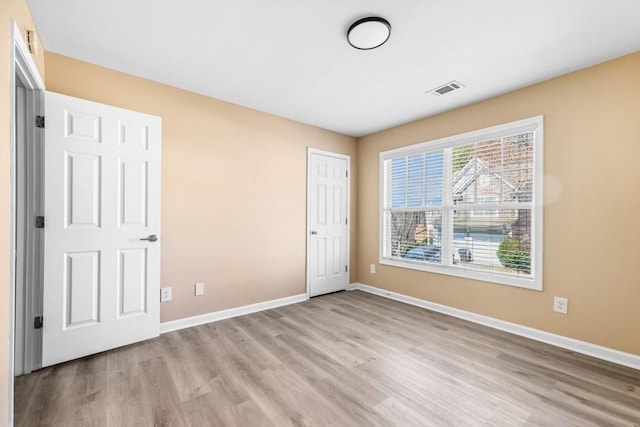 unfurnished bedroom featuring visible vents, baseboards, and light wood finished floors