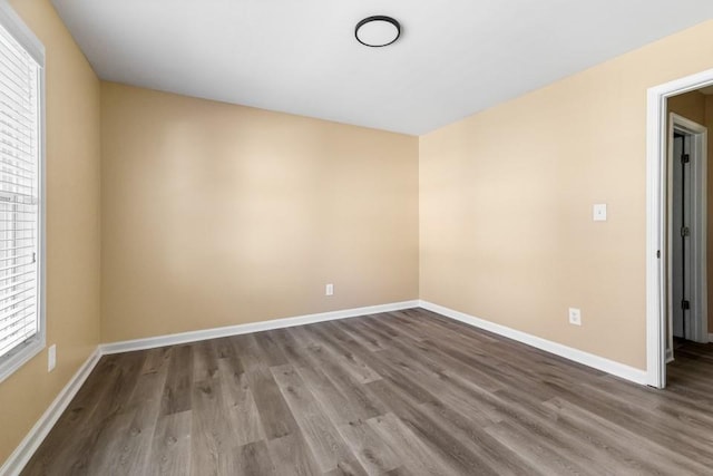 spare room featuring wood finished floors and baseboards