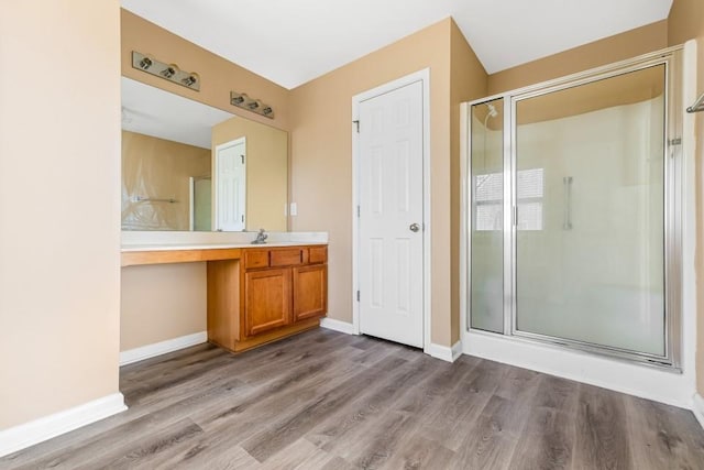 full bathroom featuring wood finished floors, a stall shower, and baseboards