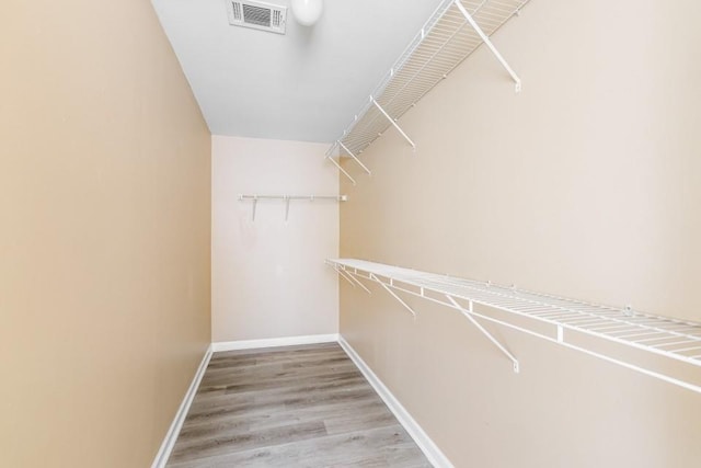 spacious closet featuring wood finished floors and visible vents