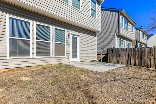 rear view of property with a patio, fence, and a lawn