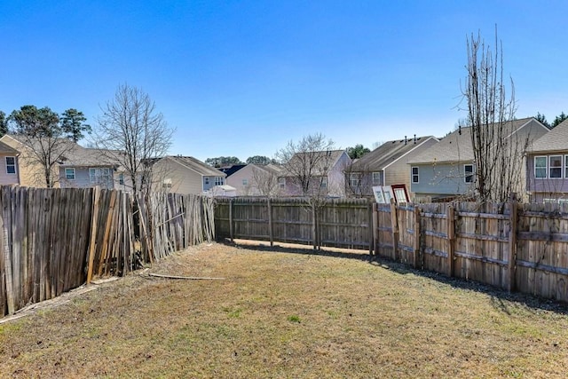 view of yard with a fenced backyard and a residential view