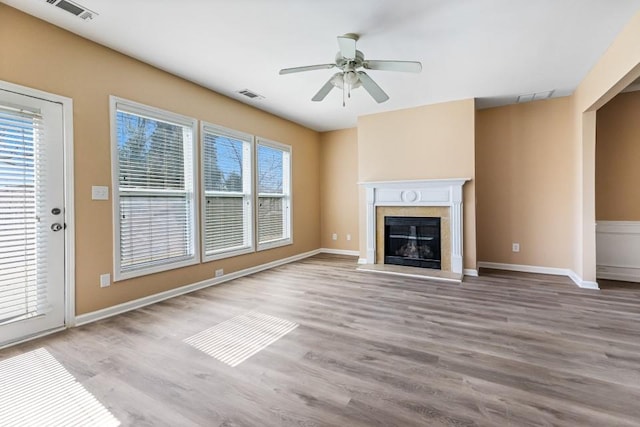 unfurnished living room with visible vents, wood finished floors, and a premium fireplace