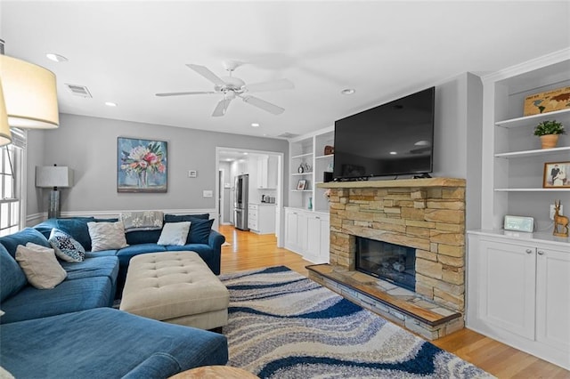 1959 Audubon Dr NE, Atlanta, GA 30329 - living area with built in features, light wood finished floors, a ceiling fan, a stone fireplace, and recessed lighting