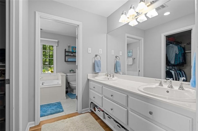 1959 Audubon Dr NE, Atlanta, GA 30329 - full bathroom featuring double vanity, wood finished floors, a spacious closet, and a bath