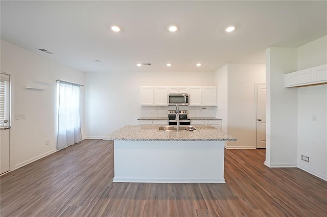 kitchen featuring white cabinetry, a center island with sink, dark hardwood / wood-style floors, and appliances with stainless steel finishes