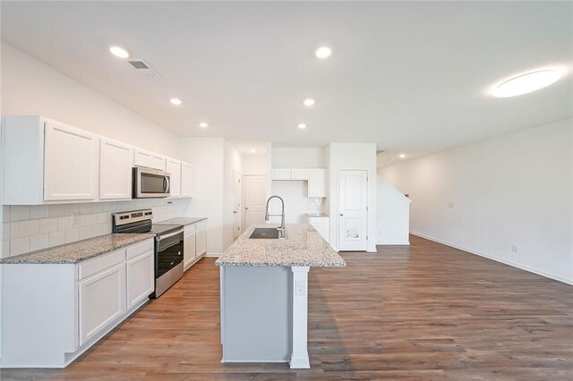 kitchen with white cabinetry, an island with sink, stainless steel appliances, and wood-type flooring