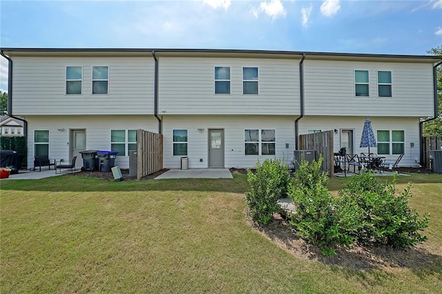 rear view of house featuring a patio, central air condition unit, and a lawn