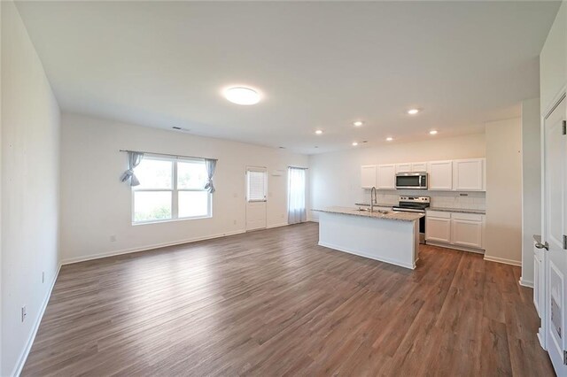 kitchen with sink, dark wood-type flooring, a center island with sink, white cabinets, and appliances with stainless steel finishes