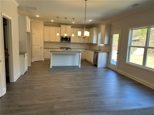 kitchen featuring stainless steel appliances, dark wood-type flooring, pendant lighting, white cabinets, and a kitchen island