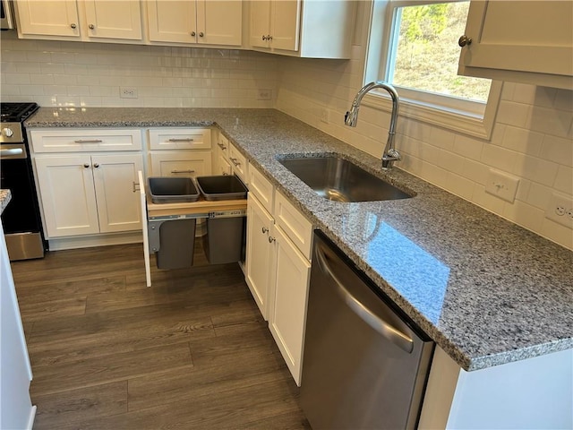 kitchen with stainless steel appliances, white cabinetry, dark wood-type flooring, and sink