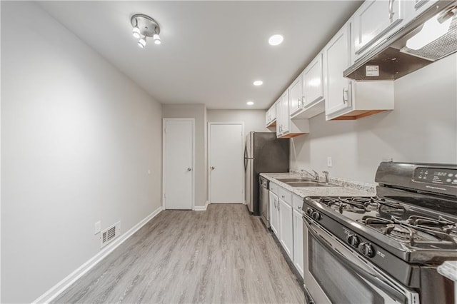 kitchen with visible vents, white cabinets, exhaust hood, appliances with stainless steel finishes, and light wood-style floors