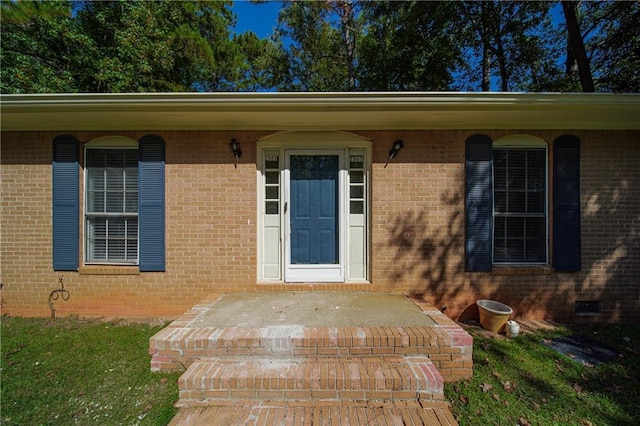 doorway to property featuring brick siding