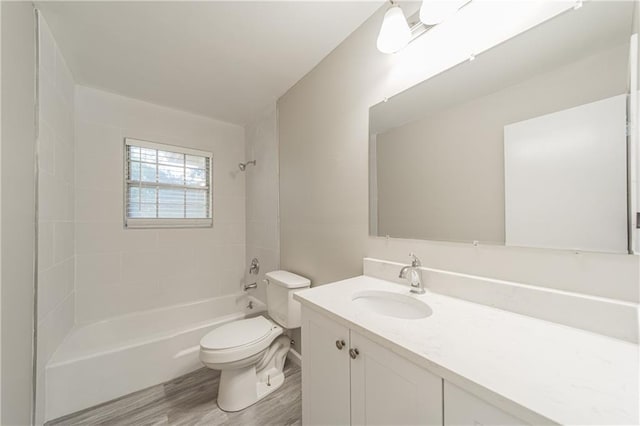 full bathroom featuring toilet, vanity, wood finished floors, and tub / shower combination