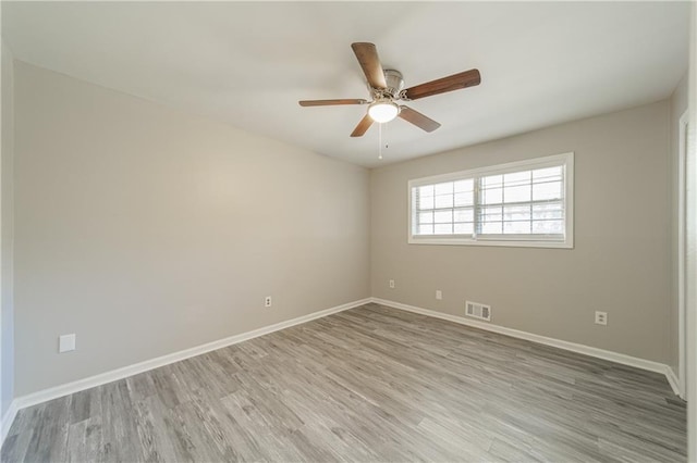 unfurnished room with visible vents, light wood-style flooring, ceiling fan, and baseboards