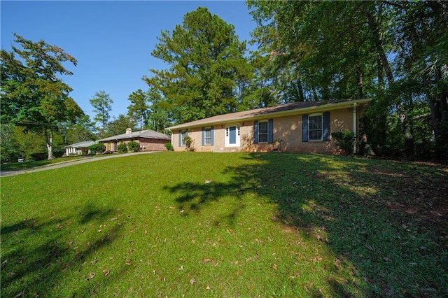 ranch-style house featuring driveway and a front lawn