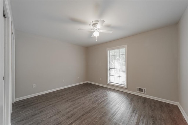 empty room with visible vents, baseboards, a ceiling fan, and dark wood-style floors