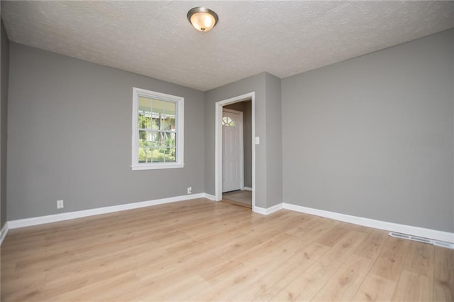 8211 Thompson St, Douglasville, GA 30134 - unfurnished room featuring light wood-style floors, baseboards, and a textured ceiling