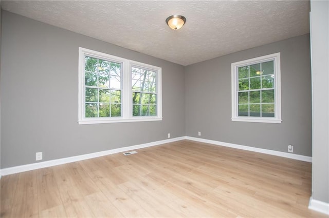 8211 Thompson St, Douglasville, GA 30134 - unfurnished room featuring visible vents, baseboards, light wood-style floors, and a textured ceiling