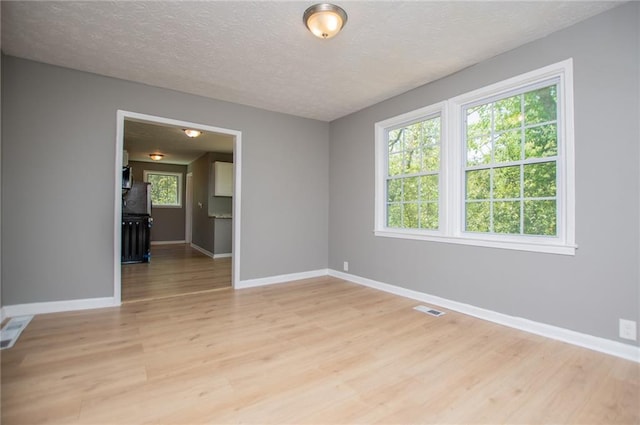 8211 Thompson St, Douglasville, GA 30134 - empty room with light wood finished floors, visible vents, baseboards, and a textured ceiling