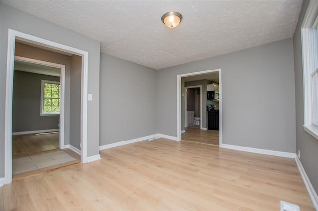 8211 Thompson St, Douglasville, GA 30134 - empty room featuring visible vents, baseboards, light wood finished floors, and a textured ceiling