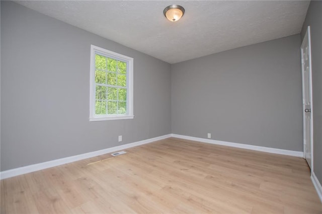 8211 Thompson St, Douglasville, GA 30134 - spare room featuring light wood-style floors, baseboards, visible vents, and a textured ceiling