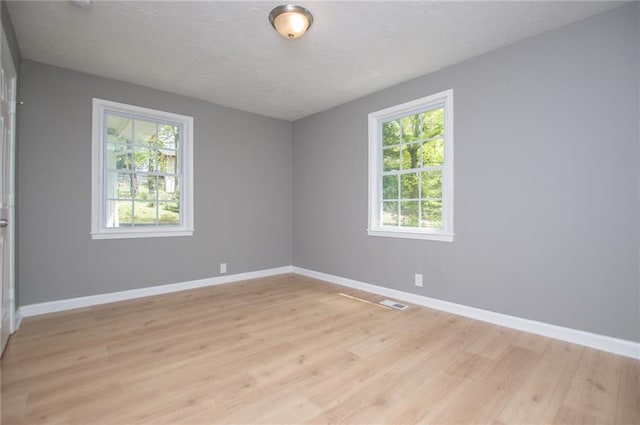 8211 Thompson St, Douglasville, GA 30134 - spare room featuring visible vents, baseboards, light wood finished floors, and a textured ceiling