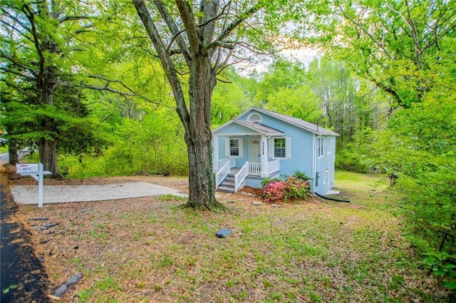 8211 Thompson St, Douglasville, GA 30134 - bungalow-style home featuring a wooded view, covered porch, and stucco siding