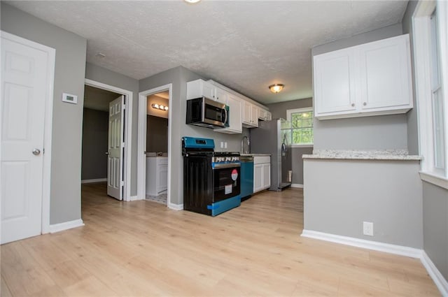 8211 Thompson St, Douglasville, GA 30134 - kitchen featuring light wood-type flooring, a textured ceiling, white cabinetry, appliances with stainless steel finishes, and baseboards