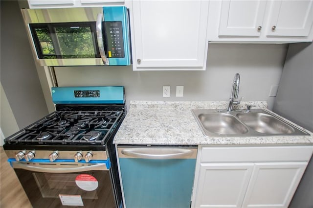 8211 Thompson St, Douglasville, GA 30134 - kitchen featuring light countertops, white cabinetry, a sink, and appliances with stainless steel finishes