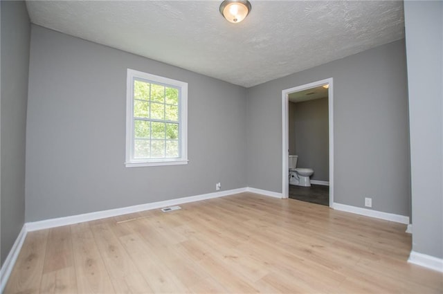 8211 Thompson St, Douglasville, GA 30134 - unfurnished room featuring visible vents, baseboards, light wood-style floors, and a textured ceiling