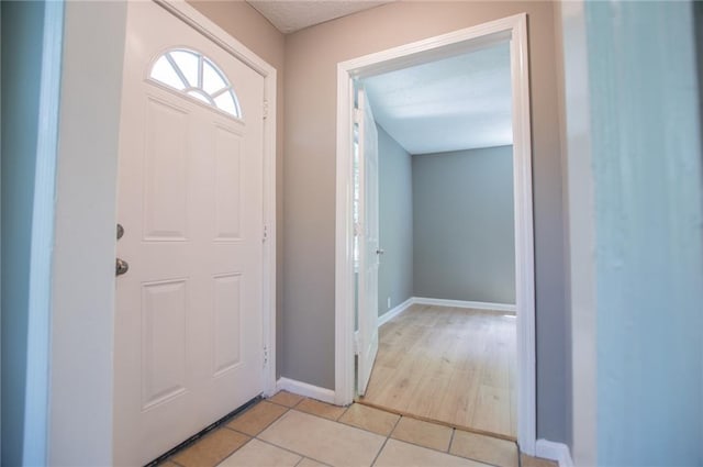8211 Thompson St, Douglasville, GA 30134 - foyer featuring a textured ceiling, light tile patterned floors, and baseboards