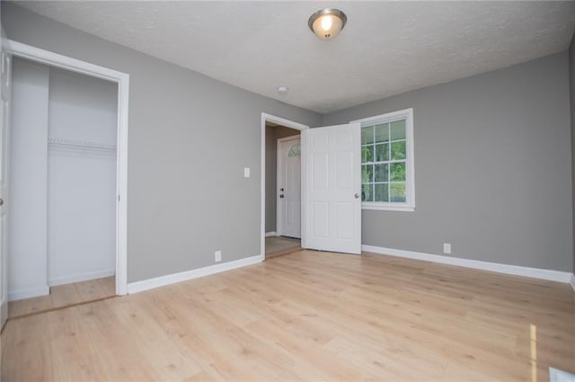 8211 Thompson St, Douglasville, GA 30134 - unfurnished bedroom with light wood-style flooring, baseboards, and a textured ceiling