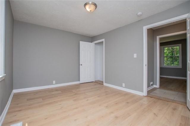 8211 Thompson St, Douglasville, GA 30134 - empty room with light wood-style floors, baseboards, and a textured ceiling