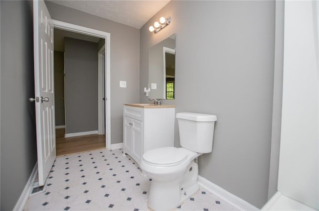 8211 Thompson St, Douglasville, GA 30134 - bathroom featuring vanity, baseboards, a textured ceiling, and toilet