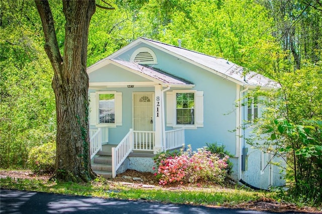 8211 Thompson St, Douglasville, GA 30134 - view of front facade with a view of trees, covered porch, and stucco siding