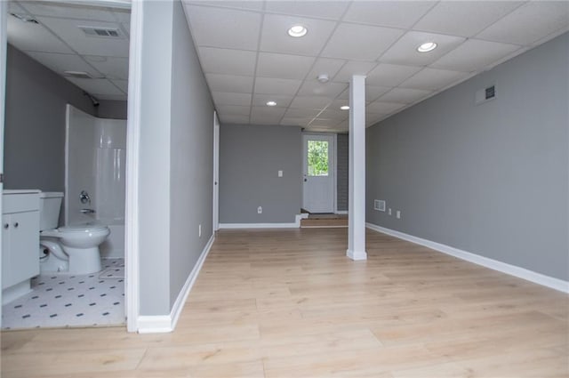 8211 Thompson St, Douglasville, GA 30134 - below grade area featuring light wood-type flooring, a paneled ceiling, baseboards, and visible vents