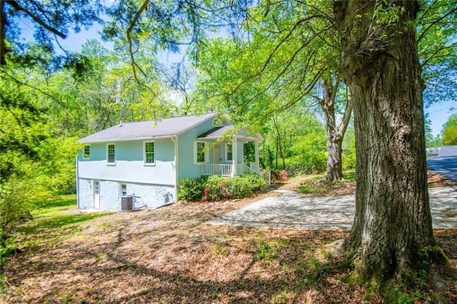 8211 Thompson St, Douglasville, GA 30134 - view of side of property featuring central air condition unit, stucco siding, and covered porch